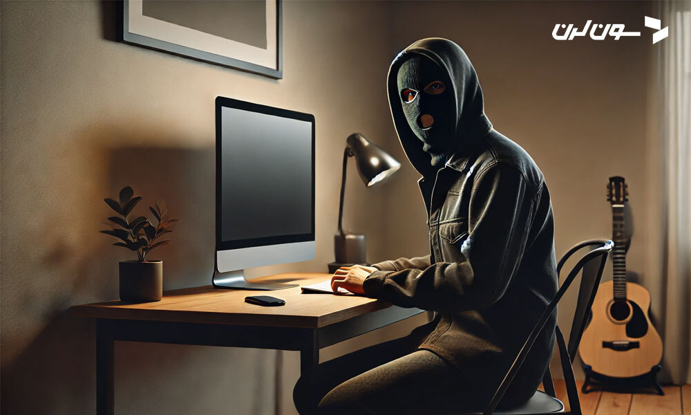 A masked individual sitting at a desk, illuminated by the glow of a computer screen in a dimly lit room.